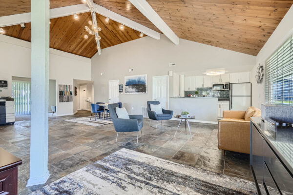 Sunset Peak apartments indoor community spaces with gray tiled floors, lounge space, and a full kitchen