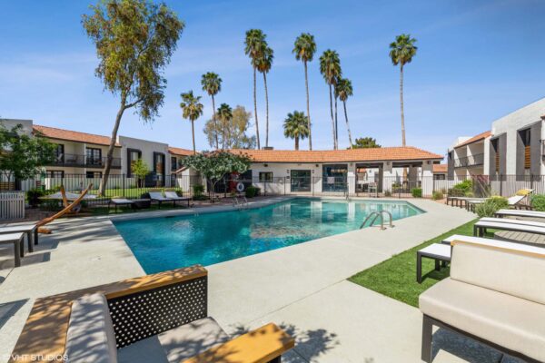 Tempe Vista apartments pool area with lounge chairs, hammocks, and tall palm trees.