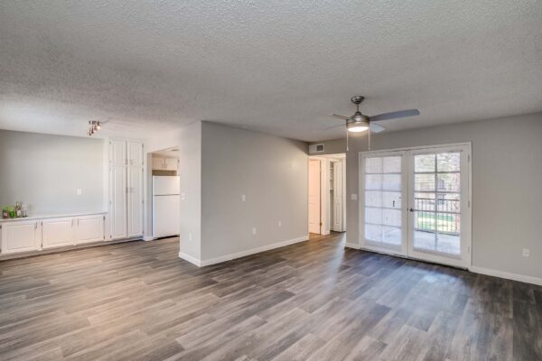Tempe Vista apartment living room with wood style floor, built in cabinets, and balcony door.