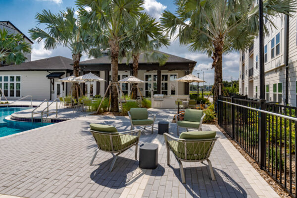 The Avery apartments pool area with lounge chairs and umbrellas.