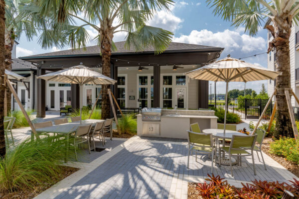 The Avery apartments outdoor lounge with dining tables and BBQ grill.