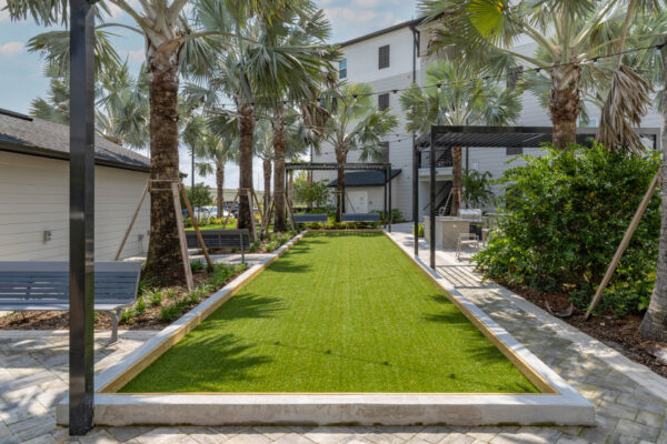 The Avery apartments outdoor lounge with turf lawn and palm trees.