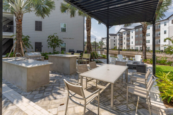 The Avery apartments outdoor lounge with dining tables and BBQ grill.