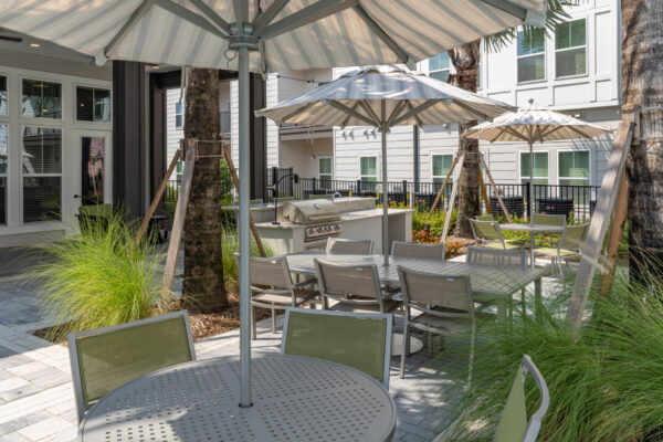 The Avery apartments outdoor lounge with dining tables and BBQ grill.