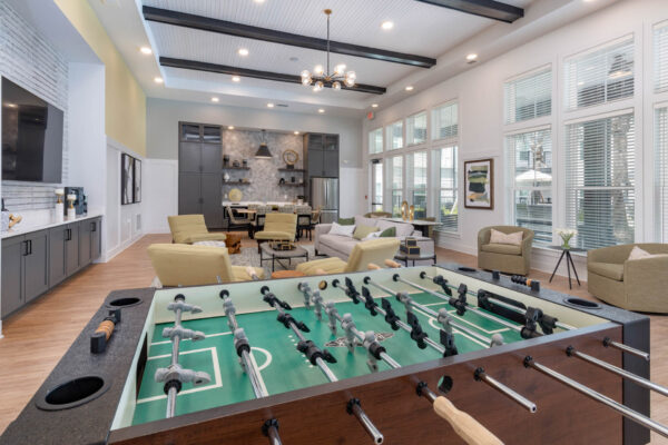 The Avery apartments lounge with plush seating, foosball table, and community kitchen.