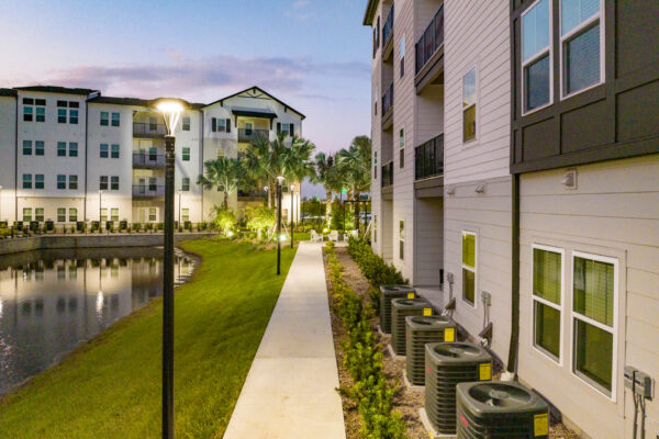 The Avery apartments pond area with lush lawn and walking paths.