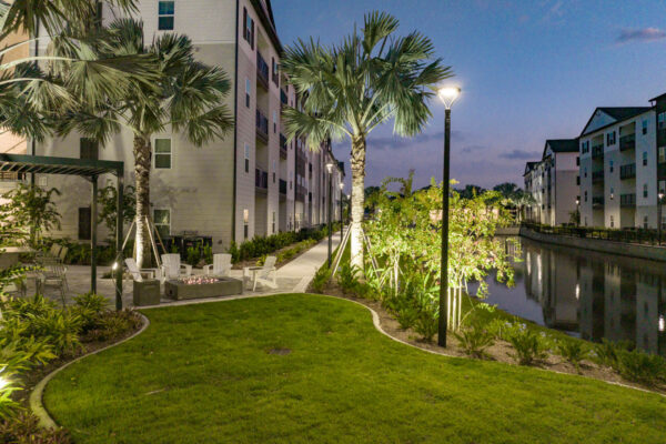 The Avery apartments outdoor lounge with lush lawn, chairs, and firepit.