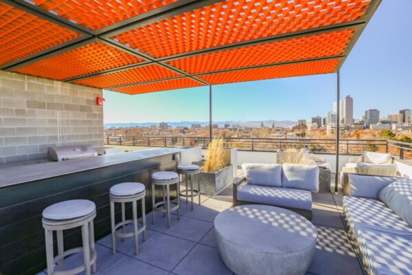 The Economist apartments rooftop deck with BBQ grill, outdoor seating, and gazebo.