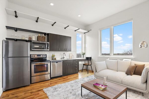 The Economist apartment living area with plush seating and modern kitchen.
