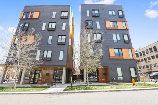 The Economist apartments with modern architecture and tall trees.