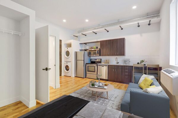 The Economist apartment living area with plush seating, modern kitchen, and large windows.