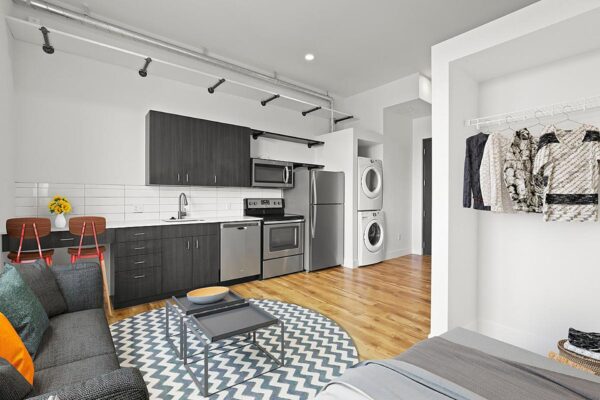 The Economist apartment living area with plush seating, modern kitchen, and large closet.
