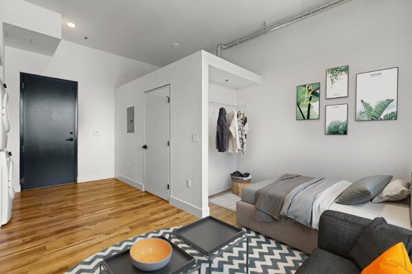 The Economist apartment living area with bed, plush seating, and large closet.