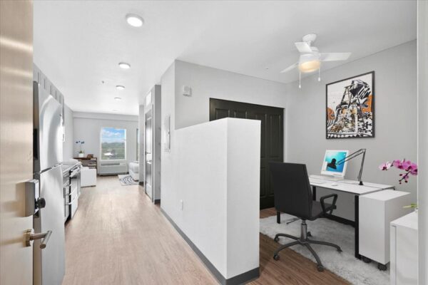 The Overland apartment with computer desk and wall art.