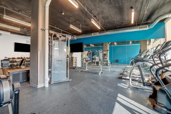 The Overland apartments fitness center with cardio machines and weight equipment.