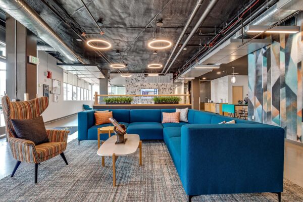 The Overland apartments lounge with plush seating, colorful wall mural, and industrial styling.