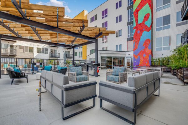 The Overland apartments rooftop lounge with plush seating, pergolas, and large mural.