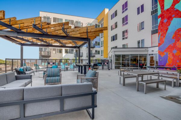 The Overland apartments rooftop deck with lounge chairs, pergolas, and colorful mural.