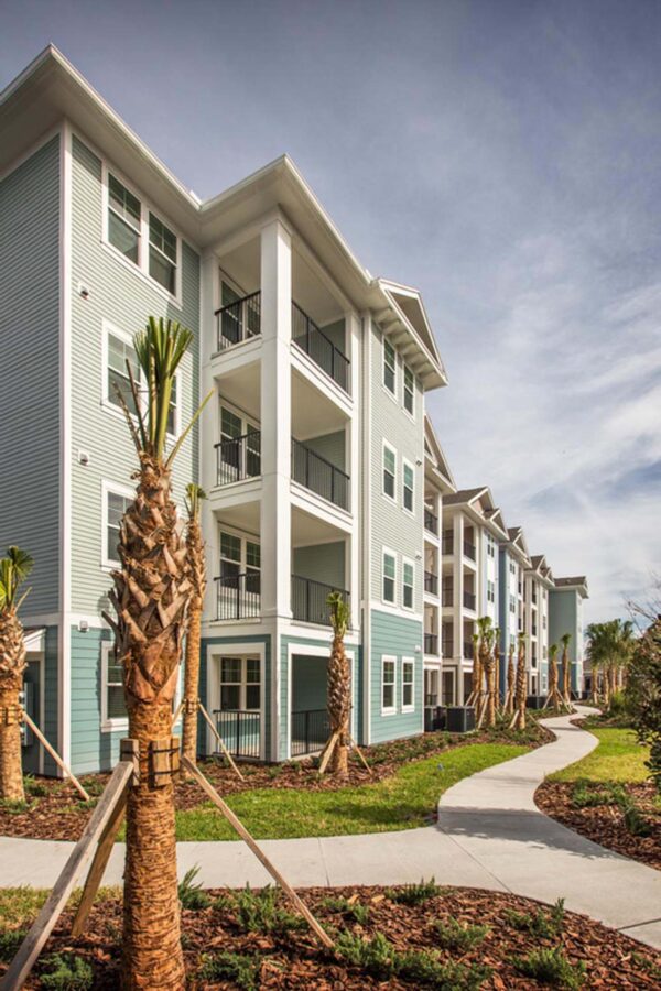 The Point at Bella Grove apartments buildings with balcony, walking path, and green landscaping.