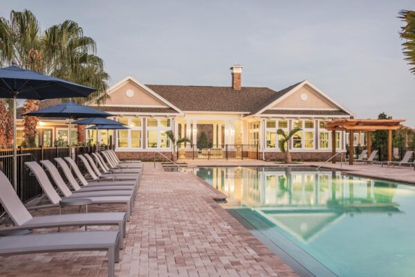 The Point at Bella Grove apartments pool area with lounge chairs, metal fencing, gazebo and palm trees.
