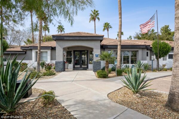 Villas at Mountain Vista Ranch apartments clubhouse with ample parking and lush desert landscaping.