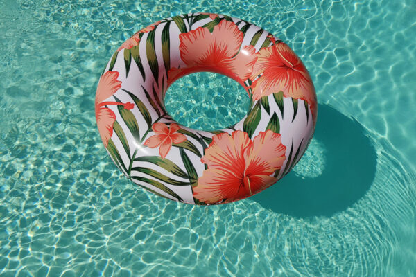 Decorated inner tube floating on shimmering pool.
