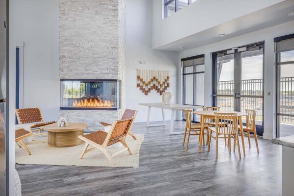 Copper 87 apartments clubhouse with wood furniture, fireplace, and large windows.