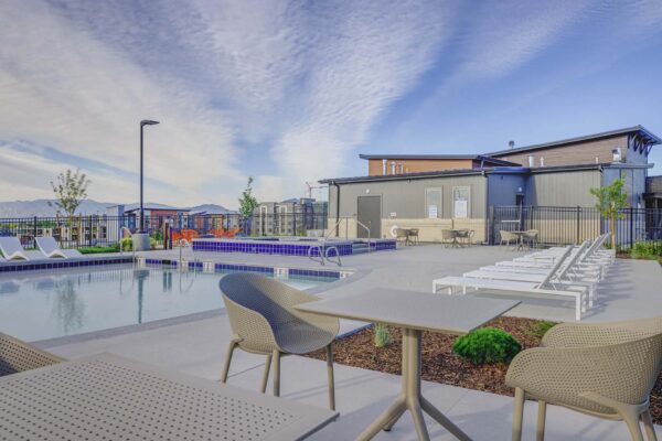 Copper 87 apartments pool area with lounge chairs and dining tables.