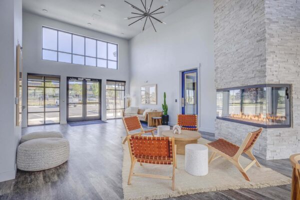 Copper 87 apartments clubhouse with wood furniture, fireplace, and large windows.