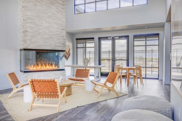 Copper 87 apartments clubhouse with wood furniture, fireplace, and large windows.