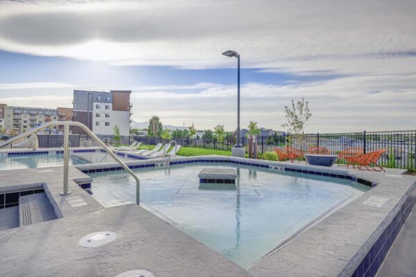 Copper 87 apartments pool area with hot tub and lounge chairs.