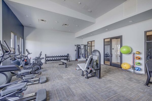 Copper 87 apartments fitness center with cardio machines and weight equipment.