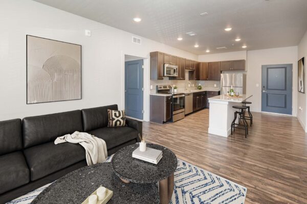 The Marc at Monument Ridge apartment living area with comfortable seating and modern kitchen.