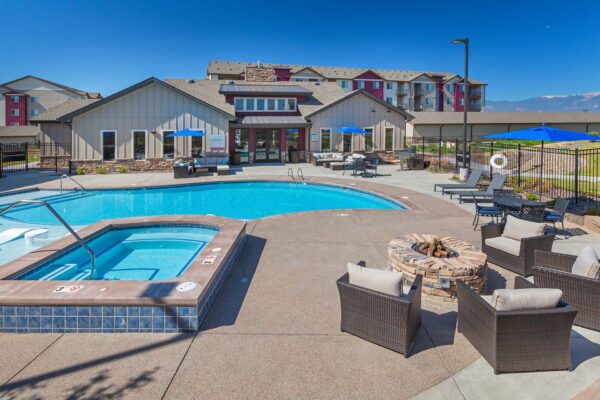 The Retreat at Patriot Park pool area with outdoor seating, fire pit, and hot tub.