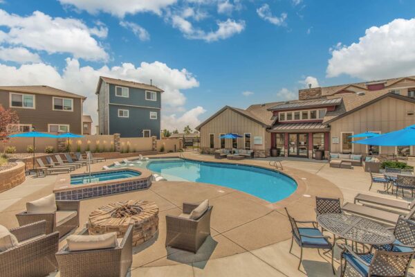 The Retreat at Patriot Park pool area with outdoor seating, lounge chairs, fire pit, and hot tub.