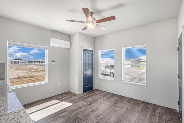 The Cottages at Woodmen Heights apartment living area with wood style floor and large windows.