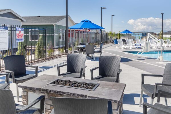 Cottages at Woodmen Heights apartment pool area with lounge chairs and fire pit.