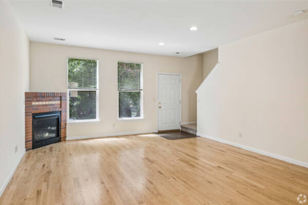Apartment living room with large windows and staircase entrtyway