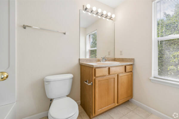 Apartment bathroom with light wood appliances and porcelain sink