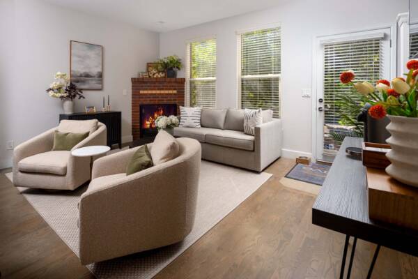 Apartment living room at Enclave Rigden Farm with plush seating and large windows.