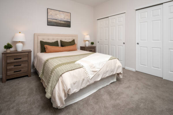 Apartment bedroom with carpet flooring and overhead lighting
