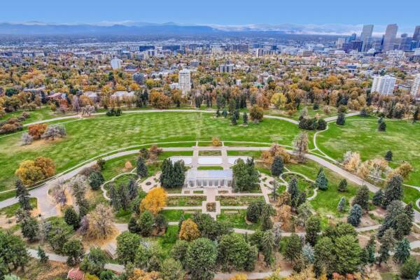 Aerial view of Cheesman Park, Denver skyline, and front range mountains.